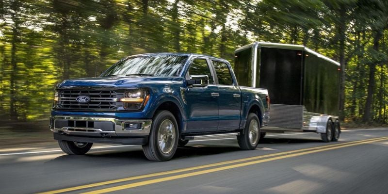 Blue Ford F-150 towing an enclosed trailer